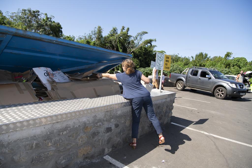 Une femme qui dépose un carton dans la poubelle