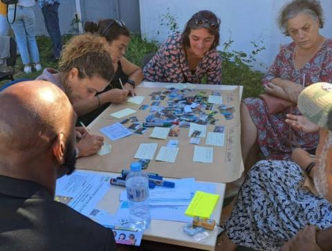 Personnes en extérieur autour d'une table pendant un atelier